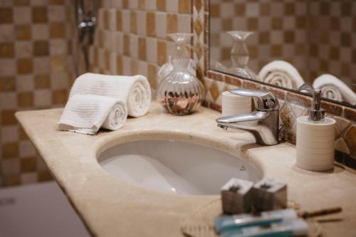 a bathroom sink with towels and a mirror at Agriturismo Tenuta La Romana in Nizza Monferrato