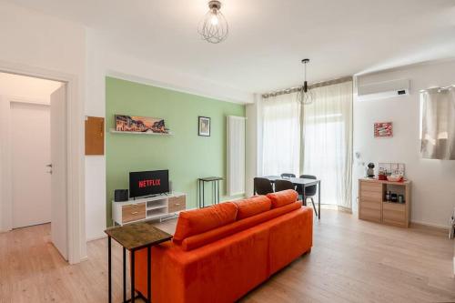 ein Wohnzimmer mit einem orangenen Sofa und einem Tisch in der Unterkunft Ospedale Niguarda - Moderno Appartamento a Milano by Hôtea in Mailand