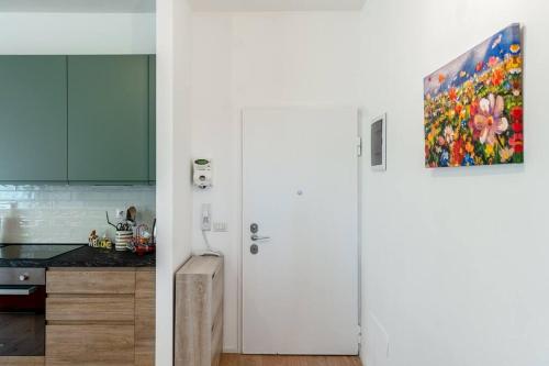 eine weiße Küche mit einem Gemälde an der Wand in der Unterkunft Ospedale Niguarda - Moderno Appartamento a Milano by Hôtea in Mailand