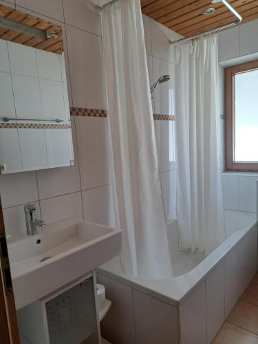 y baño con bañera, lavamanos y ducha. en Ferienwohnung Liedloff en Bad Hindelang