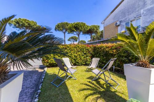 un groupe de chaises assises sur l'herbe dans une cour dans l'établissement [Cervia - 100 mt dal mare ] Villetta con giardino privato e parcheggio, à Cervia