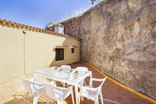 a table and chairs on a patio with a wall at Villa Palomino in Gáldar