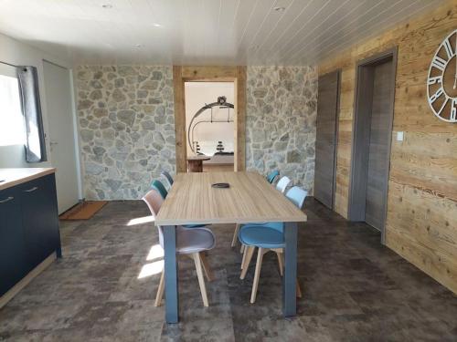 une salle à manger avec une table et des chaises en bois dans l'établissement Appartement cosy, à Gilley