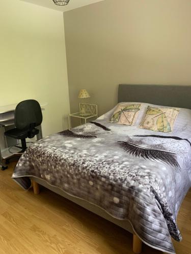 sypialnia z łóżkiem, biurkiem i krzesłem w obiekcie APPARTEMENT LE DOMAINE DES LIBELLULES PROCHE WALIBI w mieście Corbelin