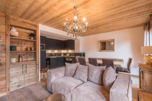 un salon avec un canapé et une cuisine dans l'établissement Duplex des Charmoz - Welkeys, à Megève