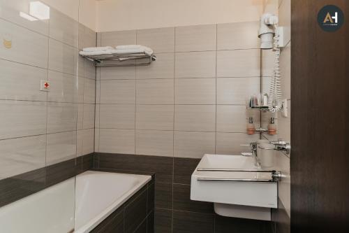 een badkamer met een bad, een wastafel en een bad bij Charlotte City Center Apartment in Košice