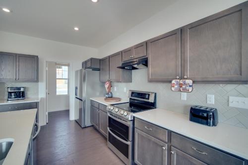 a kitchen with wooden cabinets and a counter top at Modern Canton Home 10 Mi to Lake Allatoona! in Canton