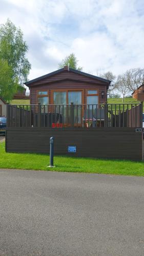 a small house with a large deck on the grass at STAG LODGE in Richmond