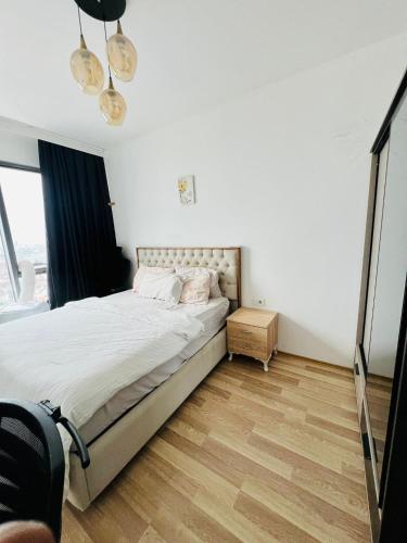 a bedroom with a bed and a wooden floor at Fully Furnished 1 Plus 1 Bedroom Suite Apartment in Esenyurt