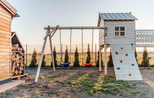 a playground with three swings and a climbing frame at Sea & Sun in Wierzchucino
