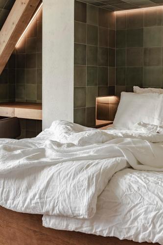 a bedroom with a large white bed with white sheets at Lukas Kapeller Hotel und Restaurant in Steyr