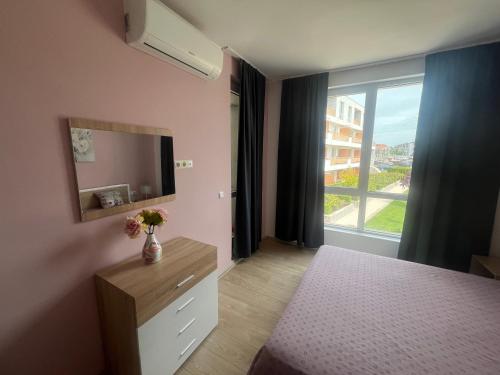 um quarto com uma cómoda, uma televisão e uma janela em Апартамент за гости Incanto del mare em Sarafovo
