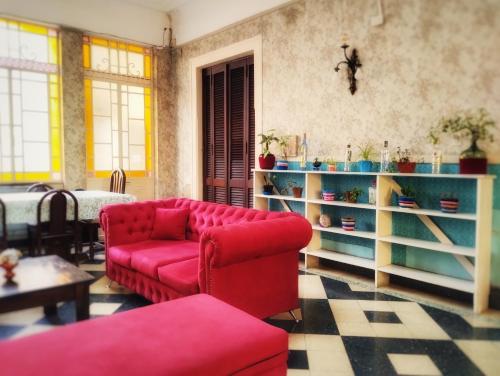 a living room with a red couch and a table at En La Plata Hostel El Pampa in La Plata