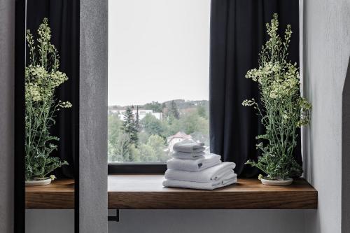 a stack of towels sitting on a shelf next to a window at Lukas Kapeller Hotel und Restaurant in Steyr