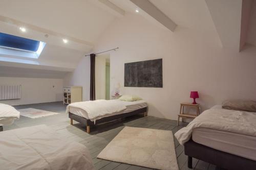 Dieses weiße Zimmer verfügt über 2 Betten und ein Fenster. in der Unterkunft Gite de charme Le Clos Michel 14 personnes piscine in Briord