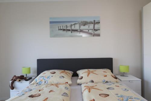 a bedroom with a bed with two pillows and a pier at Quartier Hohe Geest 17 - Nord Seestern - a69854 in Cuxhaven