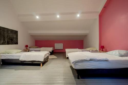 a room with four beds and a red wall at Gite de charme Le Clos Michel 14 personnes piscine in Briord