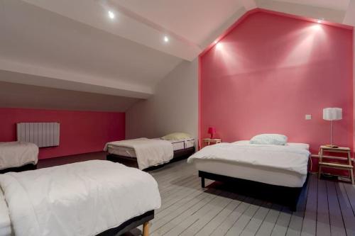 a room with three beds and a red wall at Gite de charme Le Clos Michel 14 personnes piscine in Briord