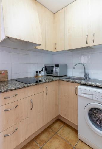 a kitchen with a sink and a washing machine at Apartamentos CASA MAREA Calella Palafrugell con Parking in Calella de Palafrugell