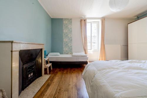 a bedroom with a bed and a fireplace at Gite de charme Le Clos Michel 14 personnes piscine in Briord