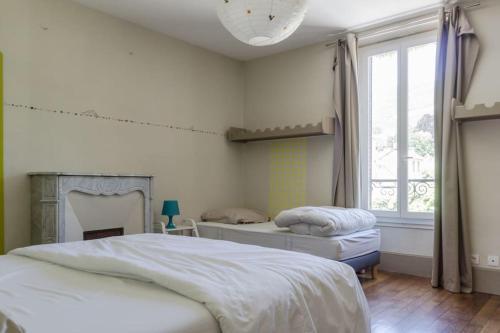 a bedroom with two beds and a window at Gite de charme Le Clos Michel 14 personnes piscine in Briord
