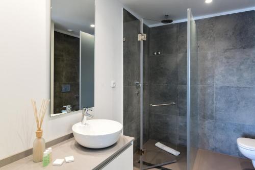 y baño con lavabo y ducha. en Oscar Concept Apartments, en Lisboa