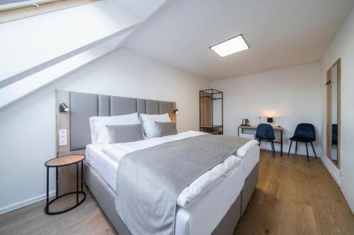 1 Schlafzimmer mit einem großen weißen Bett und 2 Stühlen in der Unterkunft Hotel LEON in Prag