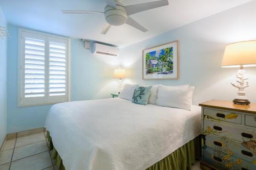 una camera con un letto bianco e una finestra di Kona Kai Resort and Gallery a Key Largo