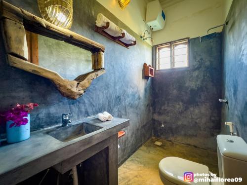 a bathroom with a sink and a toilet at Tofauti Inn in Makunduchi