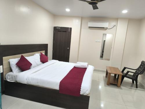 ein Schlafzimmer mit einem Bett, einem Tisch und einem Stuhl in der Unterkunft archana GRAND in Visakhapatnam
