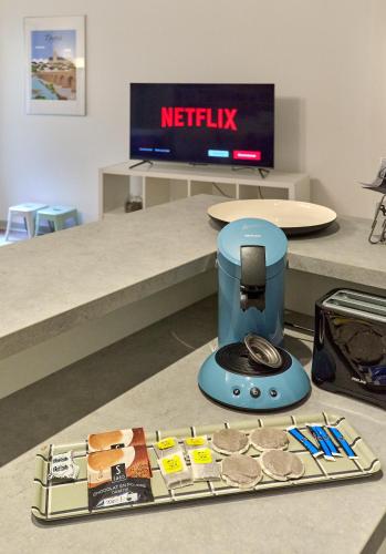 a table with a food processor and a plate of food at "La Revenderie", appartement calme sur cour privative, hyper centre de Nevers by PRMO C0NCIERGERIE in Nevers