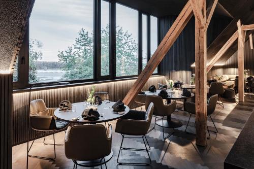 a restaurant with tables and chairs and large windows at Lukas Kapeller Hotel und Restaurant in Steyr