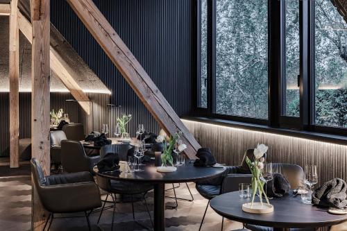 a restaurant with tables and chairs and windows at Lukas Kapeller Hotel und Restaurant in Steyr