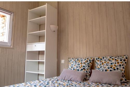 ein Schlafzimmer mit einem Bett mit Kissen und einem Bücherregal in der Unterkunft Maison 2 personnes ILE D'YEU - 2 personnes + 2 vélos in Ker Pierre Borny
