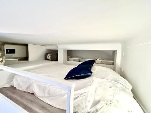 un lit blanc avec un oreiller bleu dessus dans l'établissement City Center Studio, à Nice