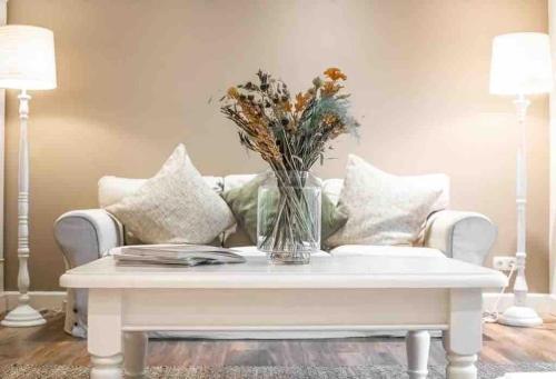 a vase of flowers on a coffee table in a living room at Van Doremaele Luxury Guesthouse in Velddriel