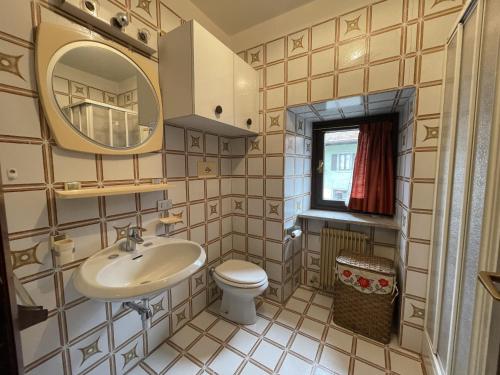 a bathroom with a sink and a toilet and a mirror at Appartamento bilocale centralissimo 013 in Pinzolo