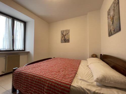 una camera con un letto con una coperta rossa di Appartamento bilocale centralissimo 013 a Pinzolo