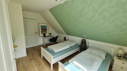 a bedroom with two beds and a table and a chair at Haus Springborn Ferienoase zwischen Strand, Feld und Wald in Biendorf