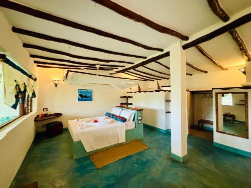 ein Zimmer mit einem Bett in der Mitte eines Zimmers in der Unterkunft Mafía Island Lodge in Utende
