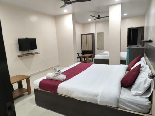 a bedroom with a large bed and a tv at archana GRAND in Visakhapatnam