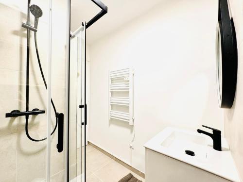une salle de bain blanche avec une douche et un lavabo dans l'établissement Le Bobillot - Studio Cozy à Cannes, à Cannes