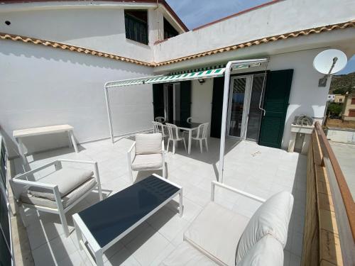 Elle comprend une terrasse dotée d'un mobilier blanc, d'une table et de chaises. dans l'établissement LA TERRAZZA DI MARTA, à Porto Empedocle