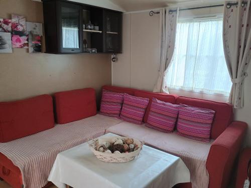 a red couch in a living room with a bowl on a table at Mobil-home issis tout confort in Hyères