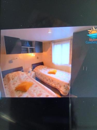 a picture of a room with two beds at Mobil-home issis tout confort in Hyères