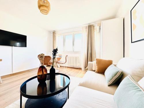 un salon avec un canapé blanc et une table en verre dans l'établissement Le Bobillot - Studio Cozy à Cannes, à Cannes