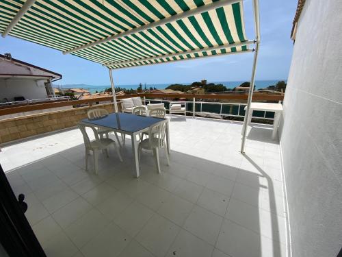 d'une terrasse sur le toit avec une table et des chaises. dans l'établissement LA TERRAZZA DI MARTA, à Porto Empedocle