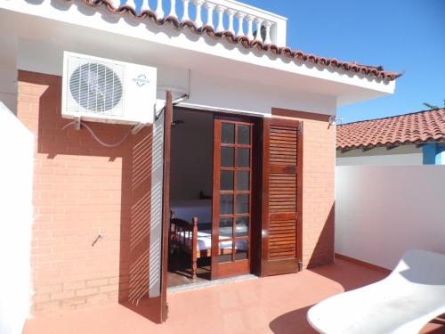 a view of a house with a patio with a fan at Pousada Casa dos Sonhos in Rio das Ostras