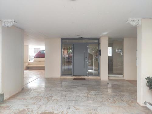 an empty room with glass doors in a building at Varkiza Sea View Apartment - Free Parking in Vari