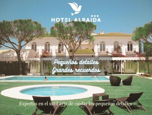 a resort with a swimming pool in front of a building at Hotel Albaida Nature in Mazagón